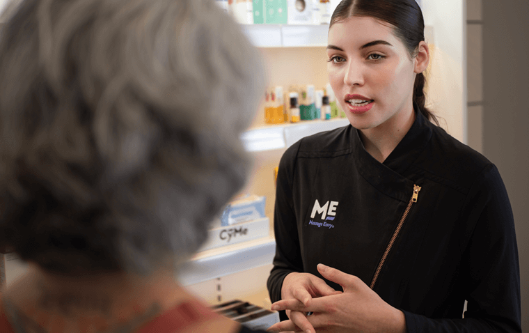 Massage Envy esthetician discussing skin care products with customer. 