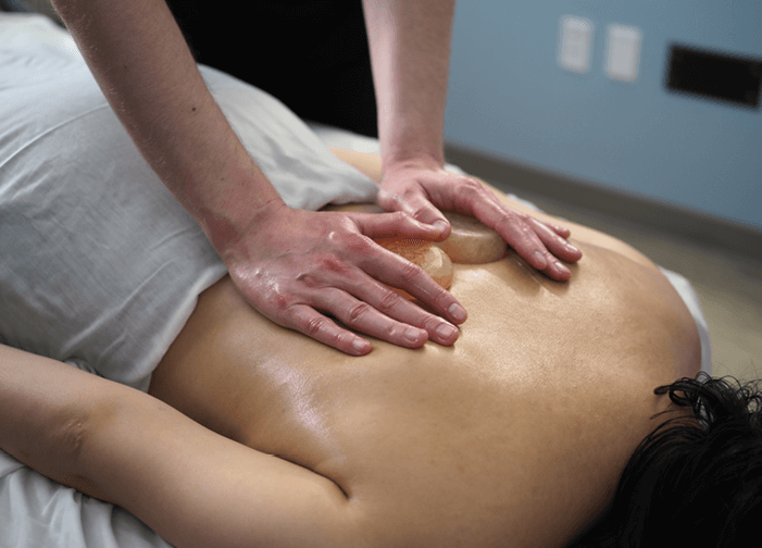 Close-up of customer's back as she receives Himalayan Salt Stone service at Massage Envy.  