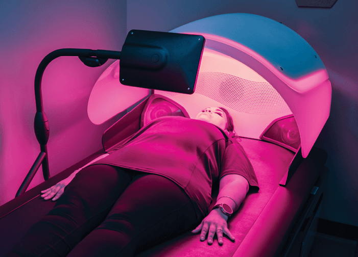 Woman relaxing with her eyes closed during HydroWave massage session. 