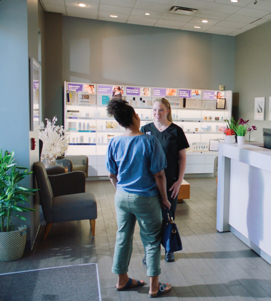 Massage Envy staff member handing tablet to client. 